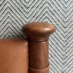 Tan leather headboard from Soho Home in front of Philip Jeffries herringbone-patterned wallpaper, creating a stylish and textured bedroom interior.