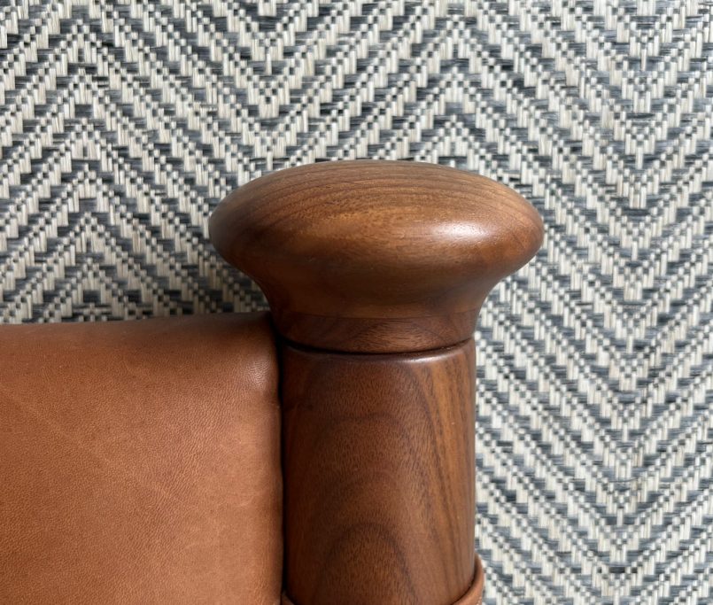 Tan leather headboard from Soho Home in front of Philip Jeffries herringbone-patterned wallpaper, creating a stylish and textured bedroom interior.